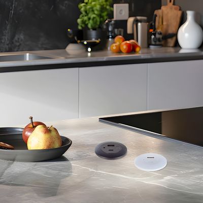 Une prise électrique en plastique montée sur une table en retrait avec des ports de charge USB A+C