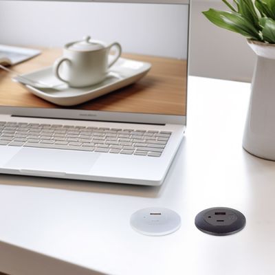 Une prise électrique en plastique montée sur une table en retrait avec des ports de charge USB A+C